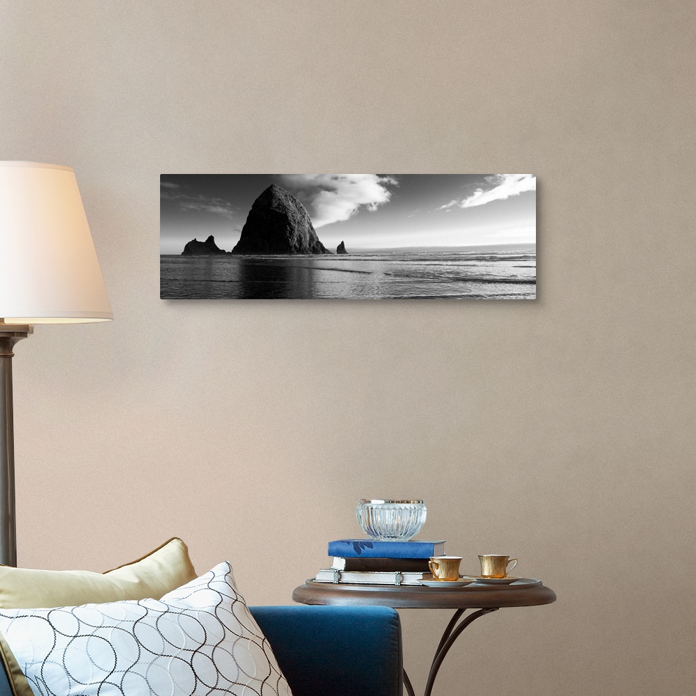 A traditional room featuring Black and white panoramic photograph of Haystack Rock with rippling waters.