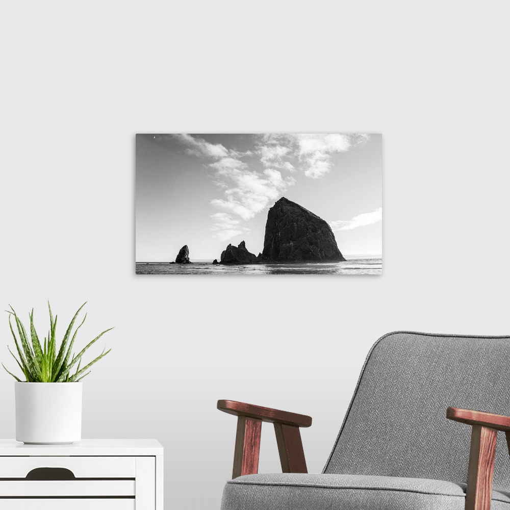 A modern room featuring Black and white photograph of Haystack Rock with the moon in the top corner.