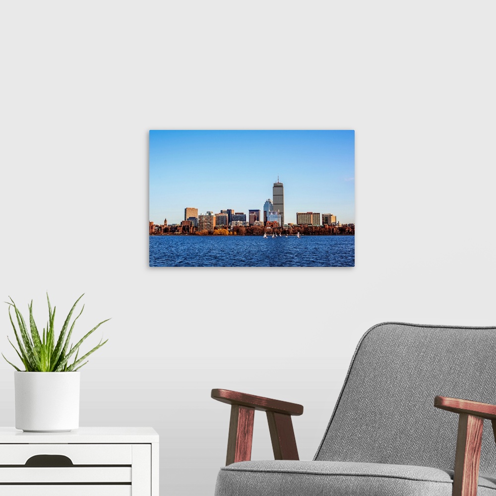 A modern room featuring View of Boston city skyline and Prudential Tower with sailboats on the Charles River.