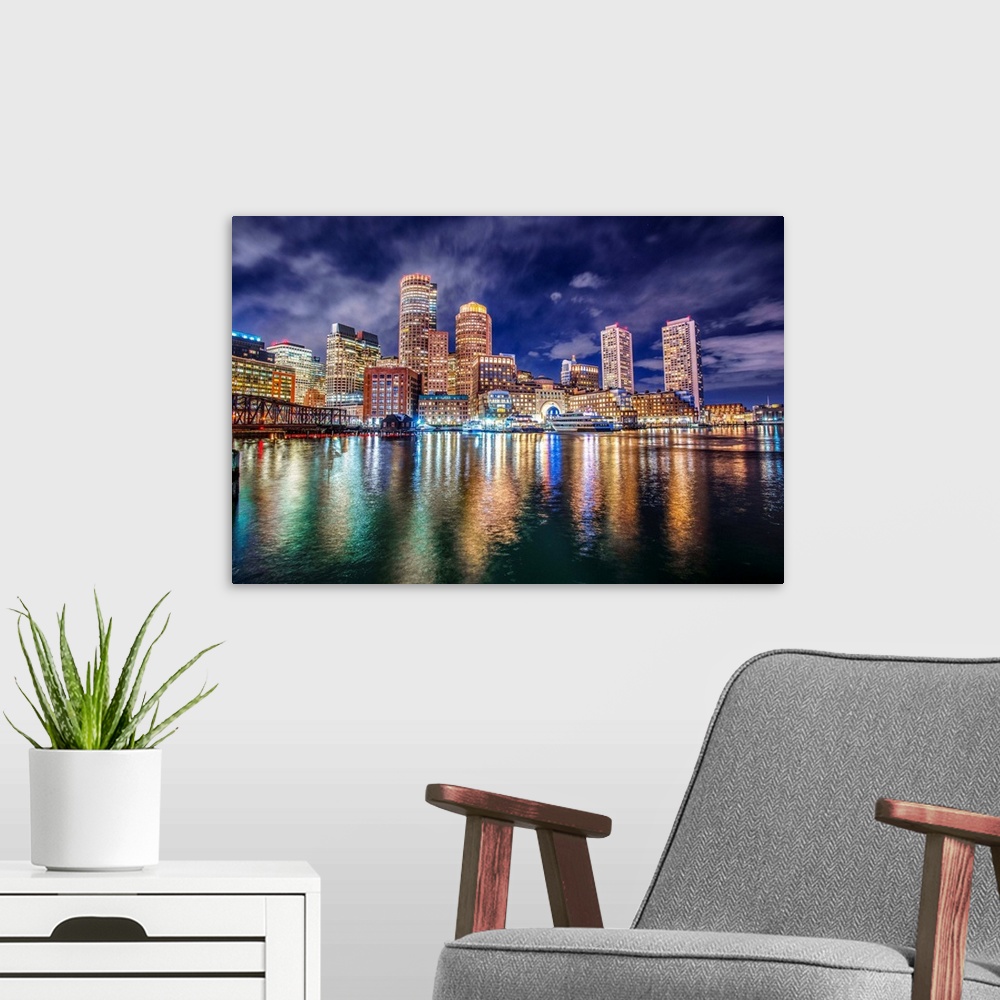 A modern room featuring The lights of downtown Boston reflect upon Massachusetts Bay.