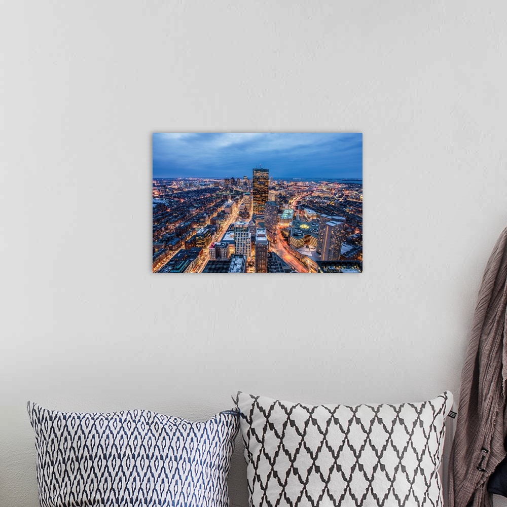 A bohemian room featuring View from a skyscraper of tall buildings in Boston glowing at night.
