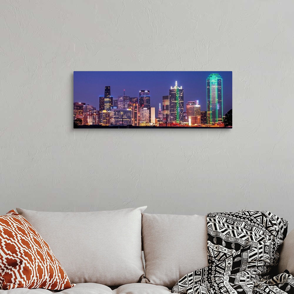 A bohemian room featuring A horizontal image of the Texas city skyline at night.