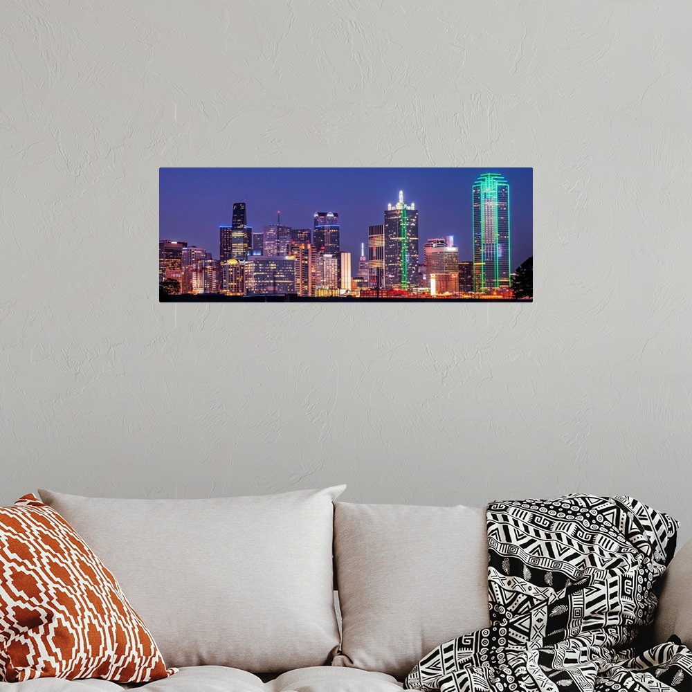 A bohemian room featuring A horizontal image of the Texas city skyline at night.