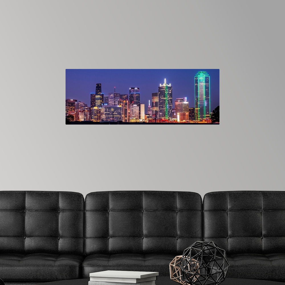 A modern room featuring A horizontal image of the Texas city skyline at night.