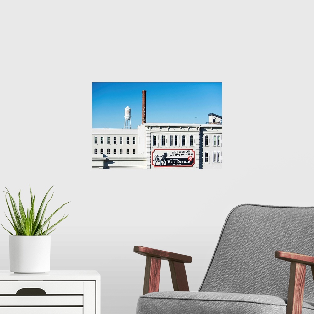 A modern room featuring Bull Durham tobacco advertisement on a building facade, Lucky Strike water tower and smokestack i...