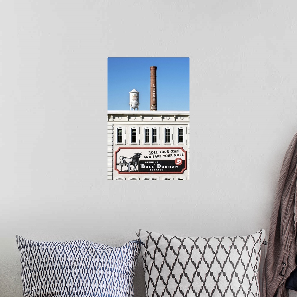 A bohemian room featuring Bull Durham tobacco advertisement on a building facade, Lucky Strike water tower and smokestack i...