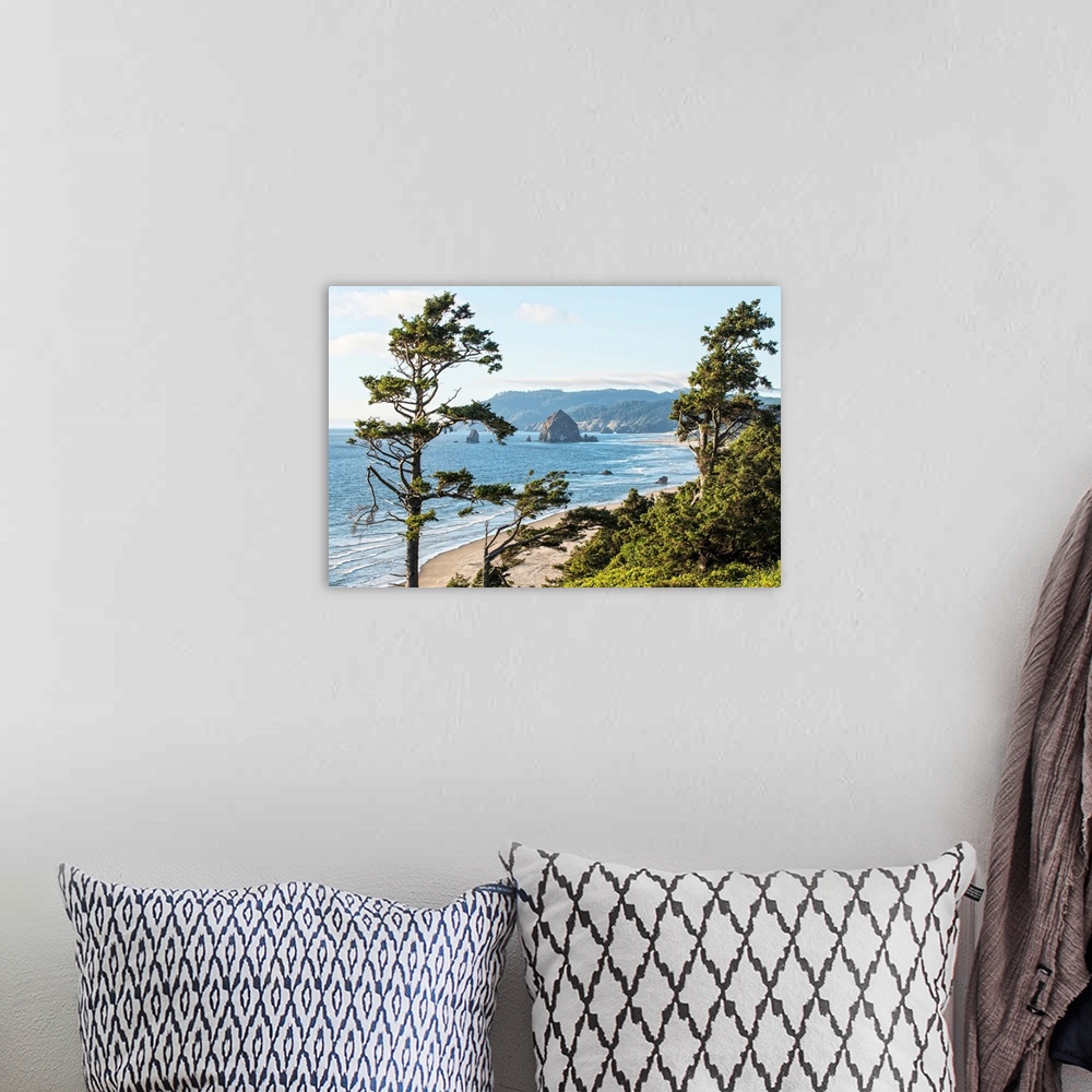 A bohemian room featuring Landscape photograph of Cannon Beach through trees with Haystack Rock in the distance.