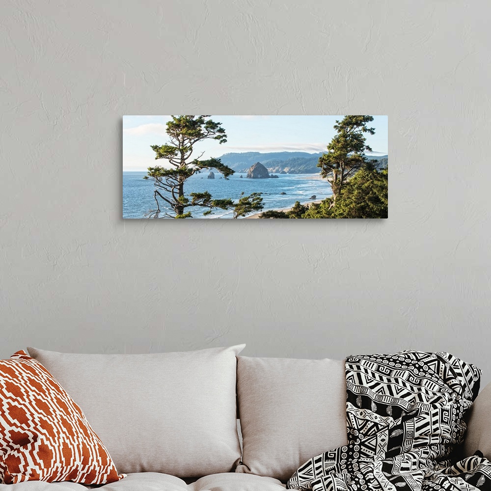 A bohemian room featuring Landscape photograph of Cannon Beach through the trees with Haystack Rock in the distance, Oregon...