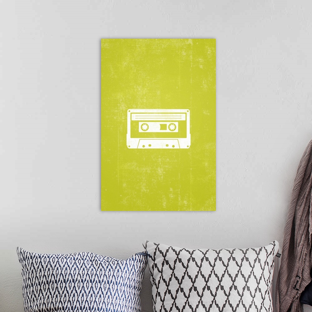 A bohemian room featuring Retro artwork that has a silhouette of a cassette tape against a neon green background.