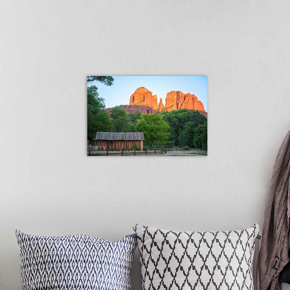 A bohemian room featuring Landscape photograph of Cathedral Rock with a rustic wooden structure in the foreground.