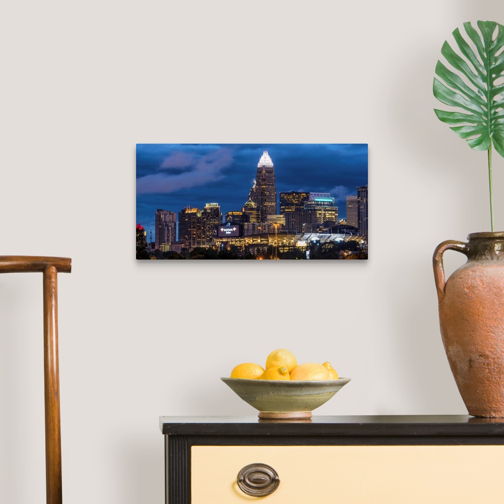 A traditional room featuring A horizontal image of the Charlotte, North Carolina city skyline at night.