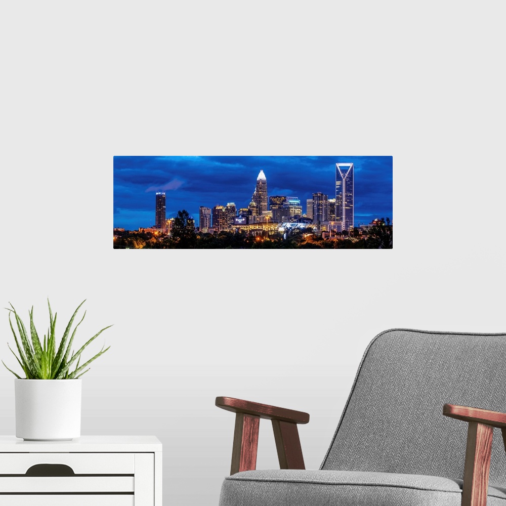 A modern room featuring Horizontal image of Charlotte, North Carolina at night with clouds in the sky.
