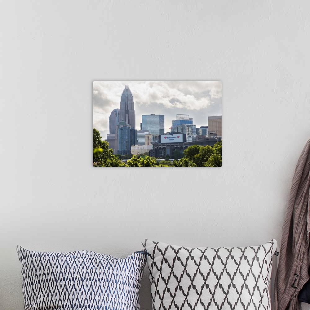 A bohemian room featuring A forest of trees in the foreground of the Charlotte North Carolina city skyline