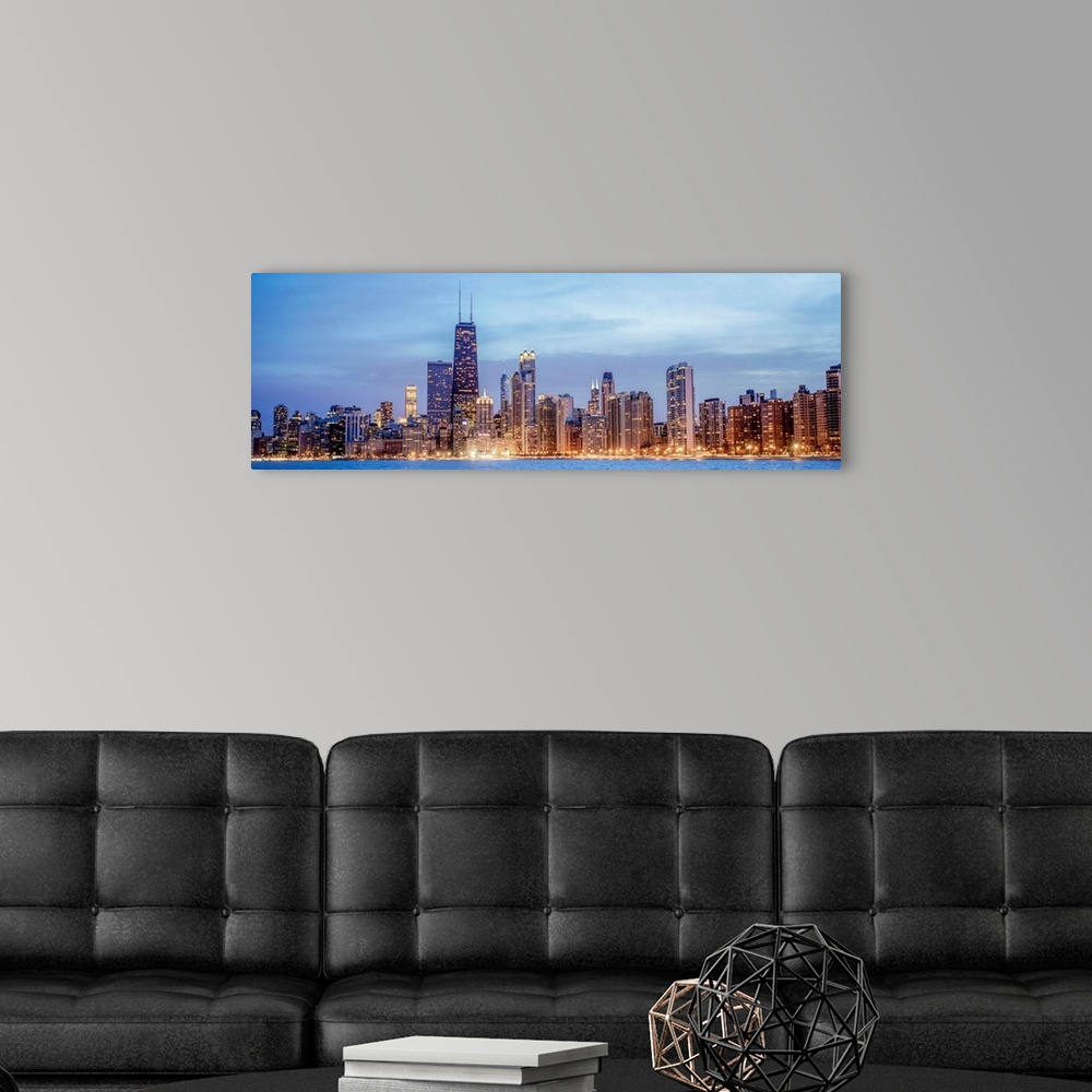A modern room featuring Panoramic view of the Chicago city skyline illuminated in the early evening, seen from the edge o...