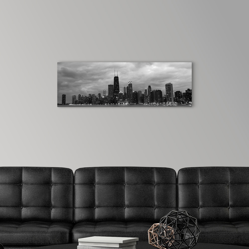 A modern room featuring Panoramic view of the Chicago city skyline illuminated in the early evening, seen from across the...