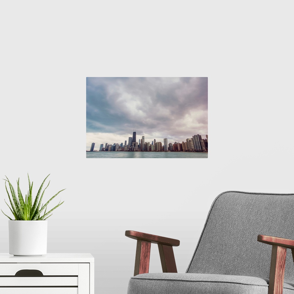 A modern room featuring Photo of Chicago's skyline under dramatic clouds.