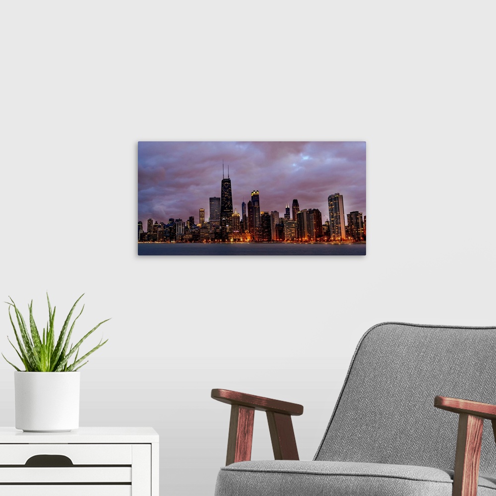 A modern room featuring Panoramic Photo of Chicago skyline at night under dramatic clouds.