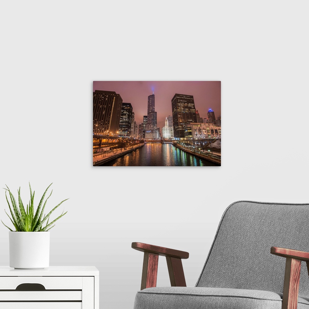 A modern room featuring Photo of tall buildings in the city of Chicago illuminated at dusk and reflected in the Chicago R...