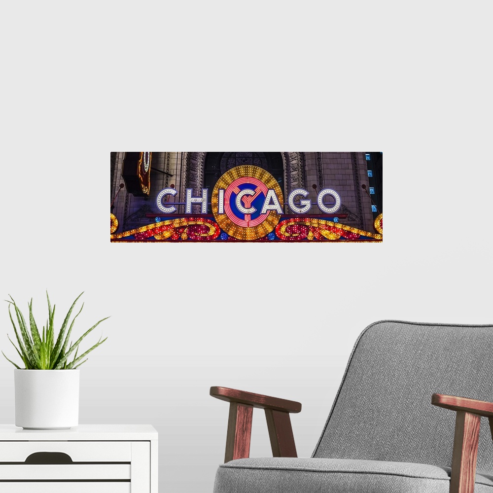 A modern room featuring Panoramic image of the Chicago Theater Marquee with glowing lights in the evening.