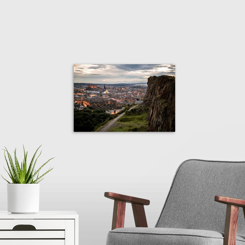 A modern room featuring Photograph of the city of Edinburgh, Scotland lit up at sunset with a view from Holyrood Park.