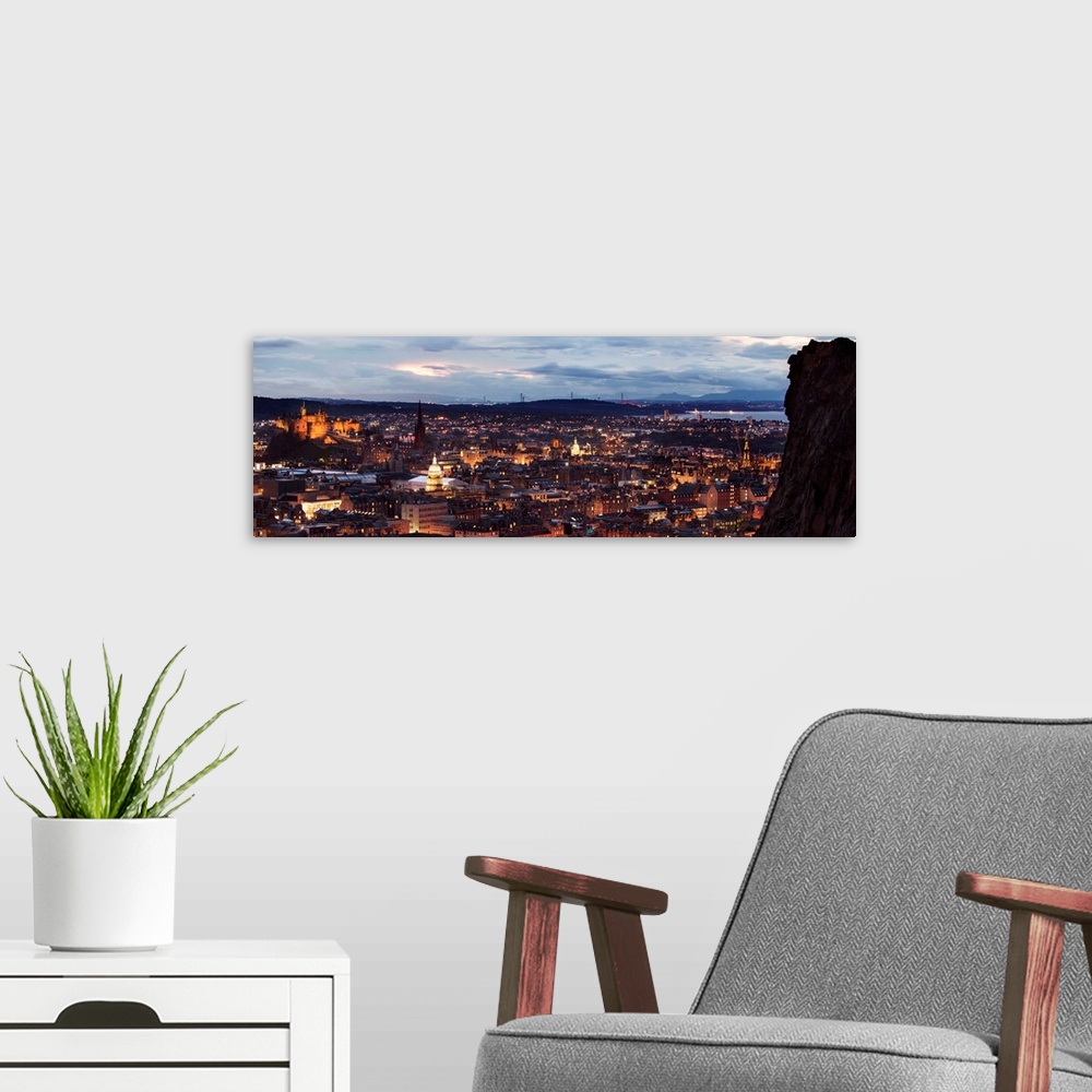 A modern room featuring Panoramic photograph of the city of Edinburgh, Scotland lit up at sunset with a view from Holyroo...