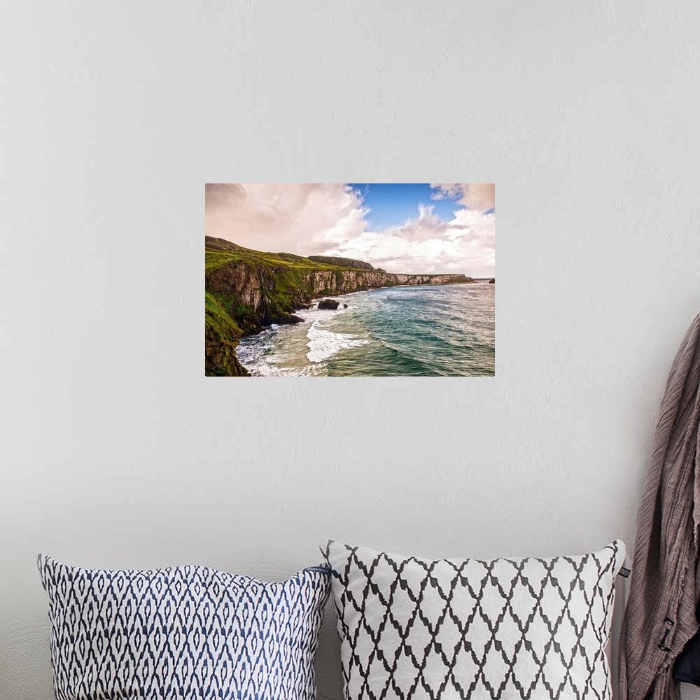 A bohemian room featuring Landscape photograph of the picturesque Cliffs of Moher with a cloudy sky above, located at the s...