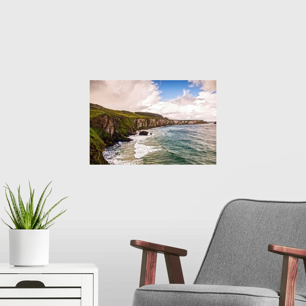 A modern room featuring Landscape photograph of the picturesque Cliffs of Moher with a cloudy sky above, located at the s...