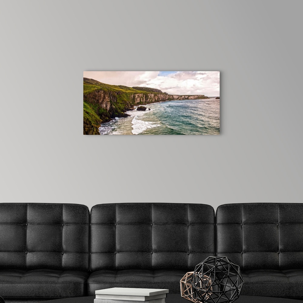 A modern room featuring Panoramic photograph of the picturesque Cliffs of Moher with a cloudy sky above, located at the s...