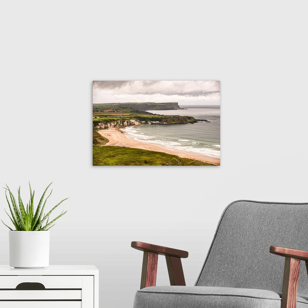 A modern room featuring Landscape photograph of an Irish coastline with dramatic clouds above, County Antrim, Ireland.