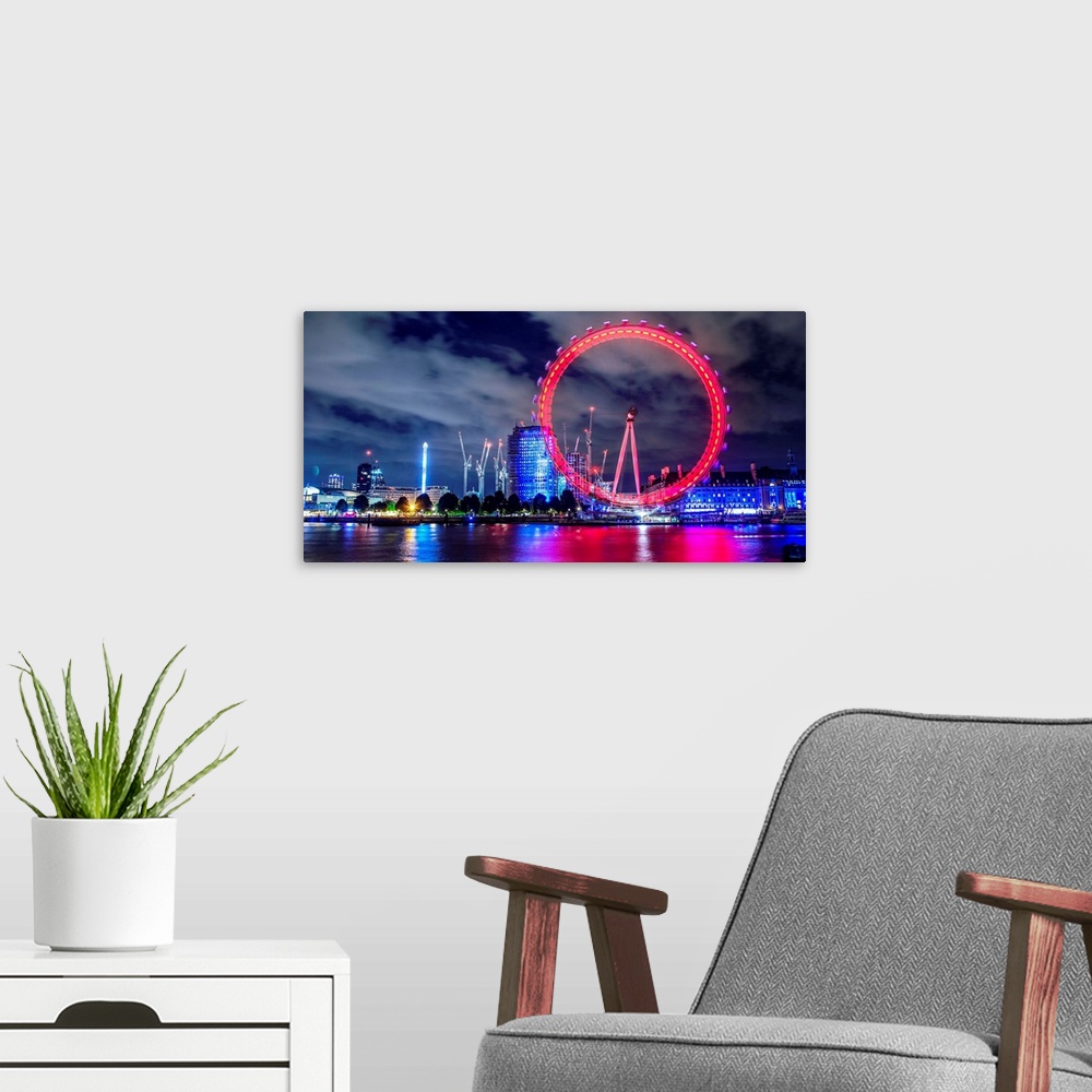 A modern room featuring View of the brightly colored ferris wheel at night in London, England.