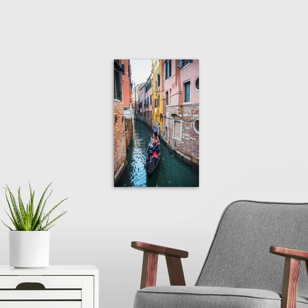 A modern room featuring Photograph of a gondola rowing though a canal surrounded by colorful building facades in Venice, ...
