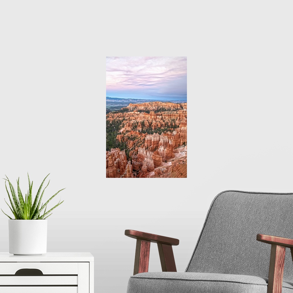 A modern room featuring Striped orange and white hoodoos and green pine trees under a pastel colored sky in Bryce Canyon ...