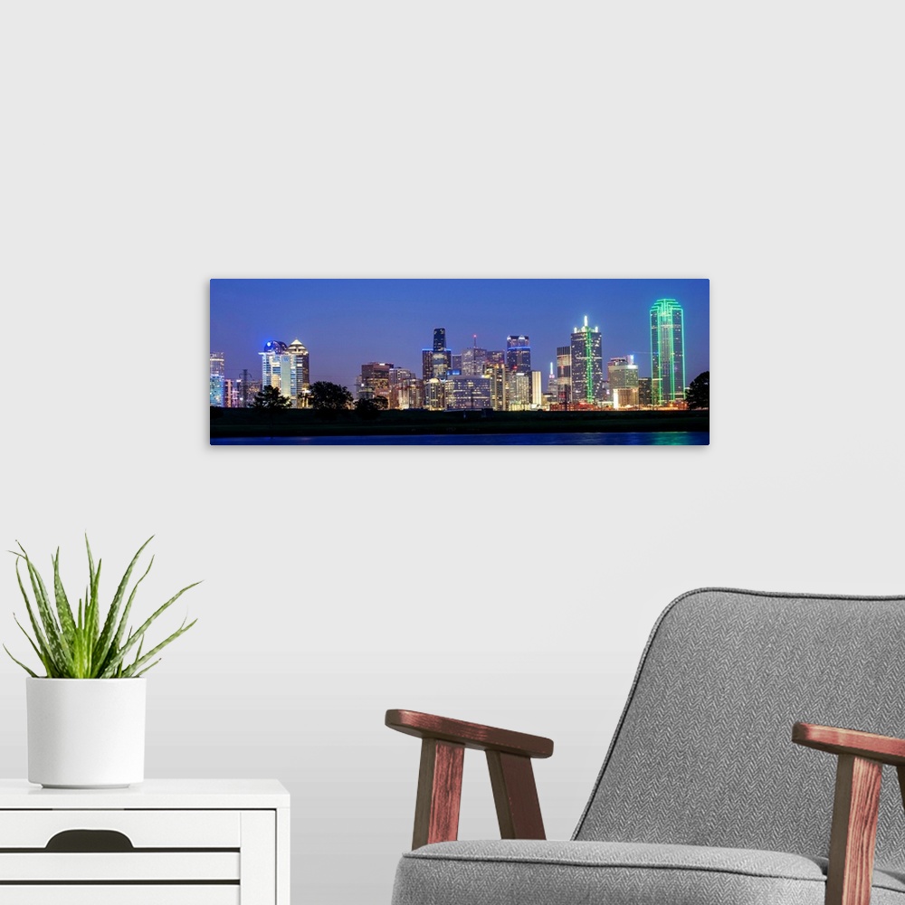 A modern room featuring The city skyline of Dallas at night.