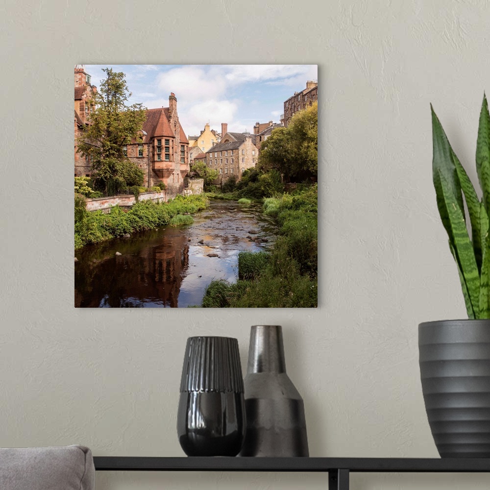 A modern room featuring Square photograph of picturesque Dean Village with Water of Leith flowing throwing through the mi...