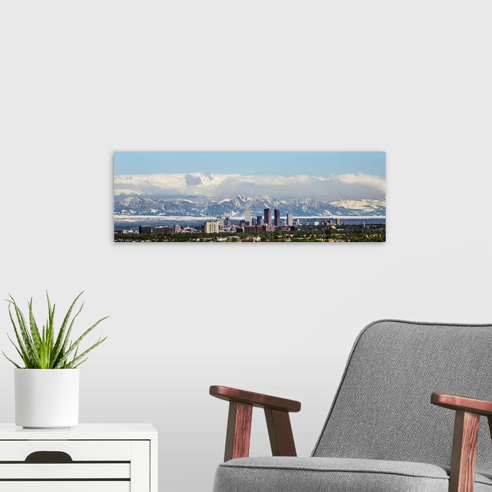 A modern room featuring Panoramic photo of a Denver skyline against a backdrop of the Rocky Mountains.