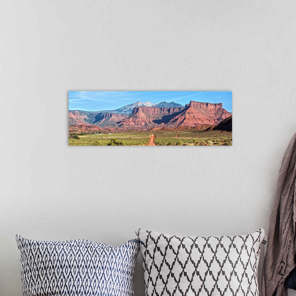 A bohemian room featuring A dirt road leading towards the sandstaone cliffs and La Sal Mountains in Arches National Park, M...