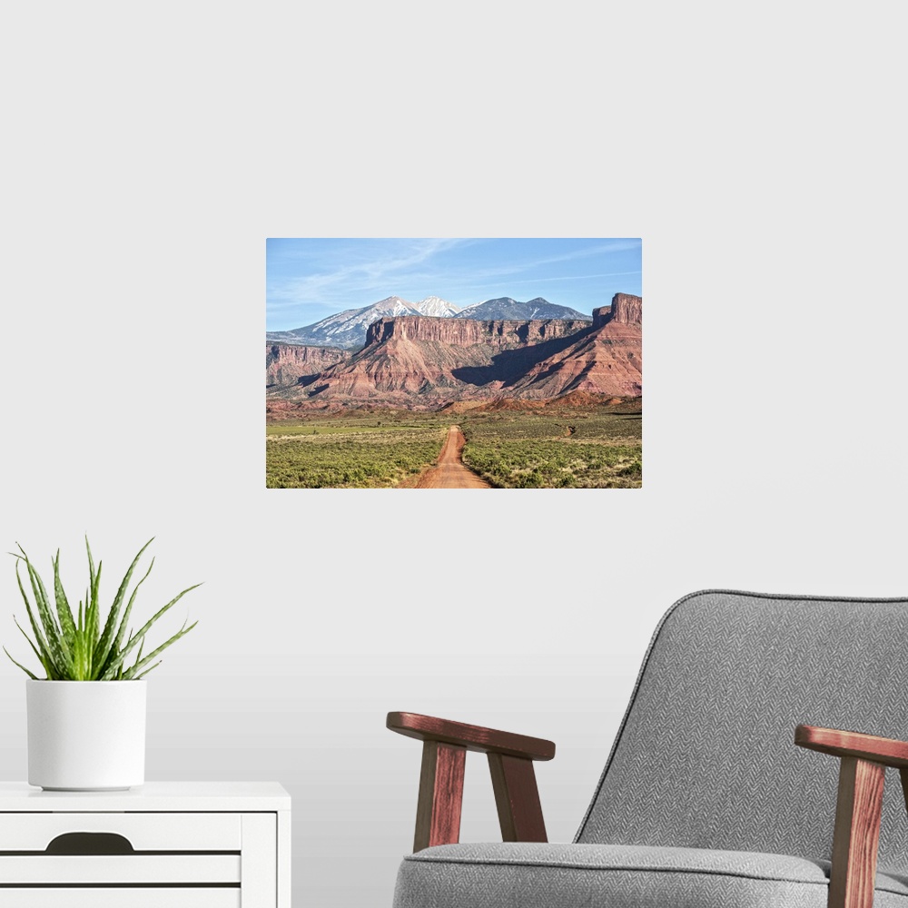 A modern room featuring A dirt road leading towards the sandstaone cliffs and La Sal Mountains in Arches National Park, M...