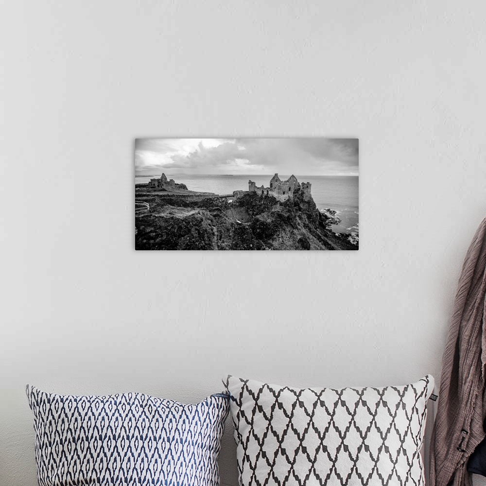 A bohemian room featuring Landscape photograph of Dunluce Castle next to the ocean, taken from a higher point.