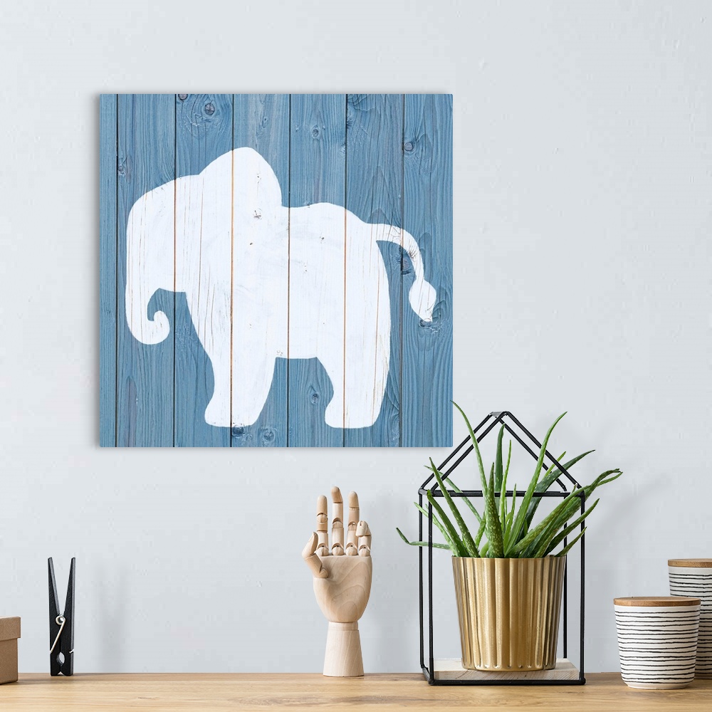 A bohemian room featuring Nursery art of an elephant outline painted on a blue board background.