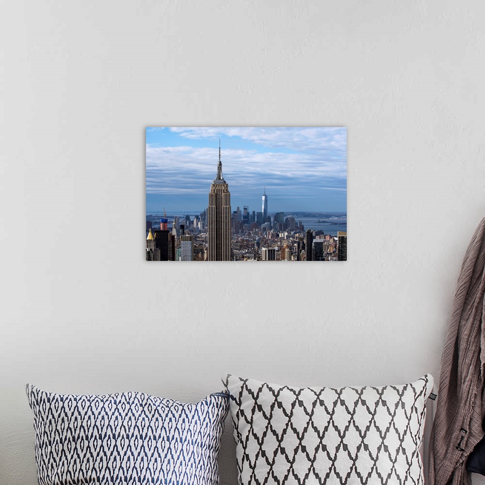A bohemian room featuring The Empire State Building rising above the New York City skyscrapers, with the One World Trade Ce...
