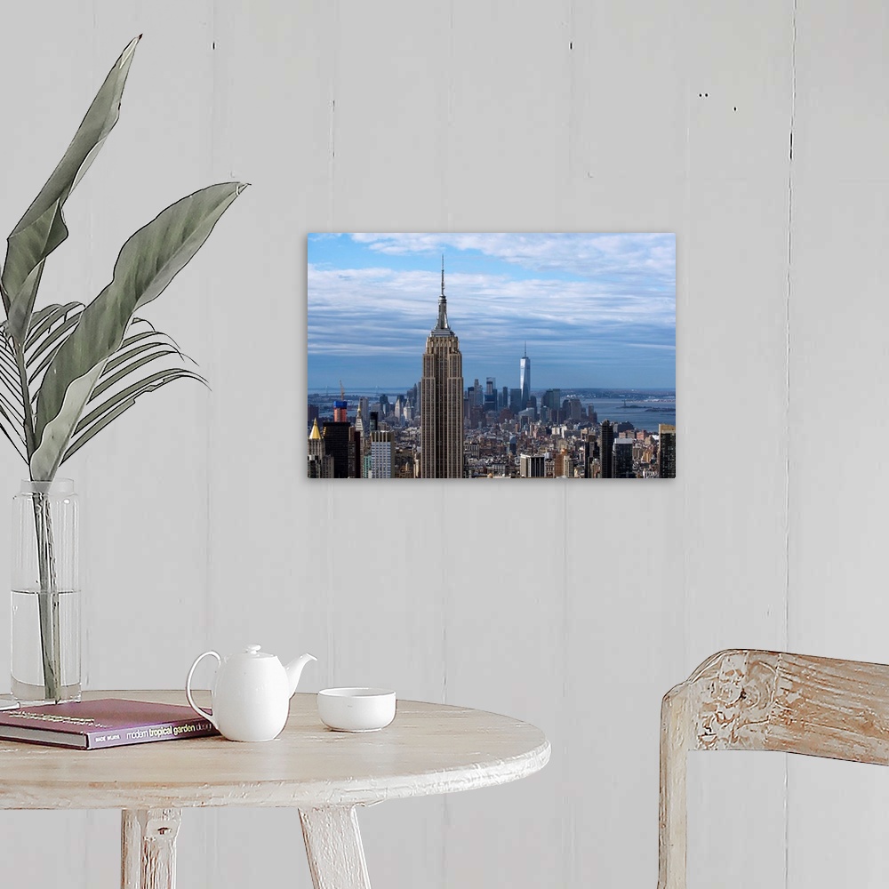 A farmhouse room featuring The Empire State Building rising above the New York City skyscrapers, with the One World Trade Ce...