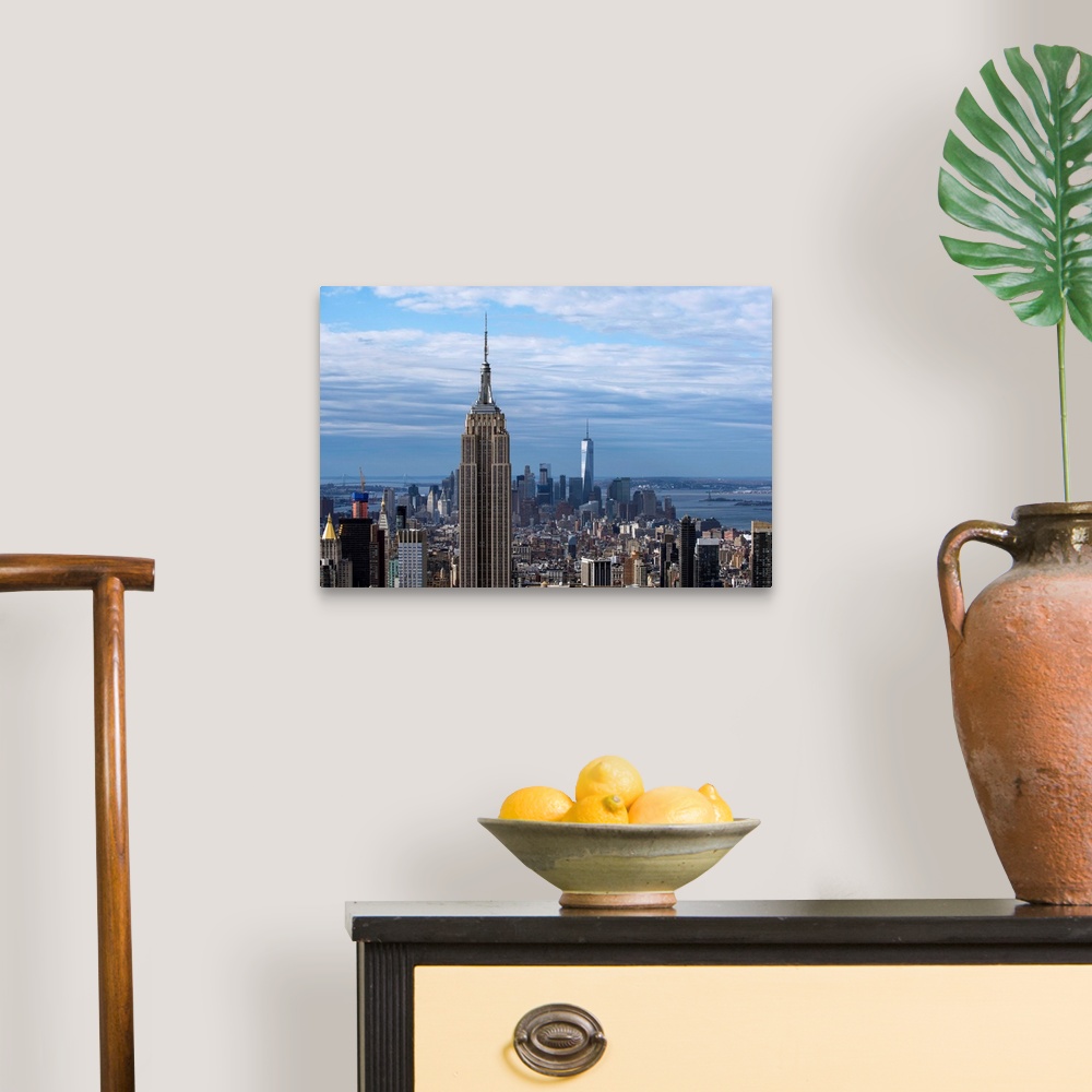 A traditional room featuring The Empire State Building rising above the New York City skyscrapers, with the One World Trade Ce...