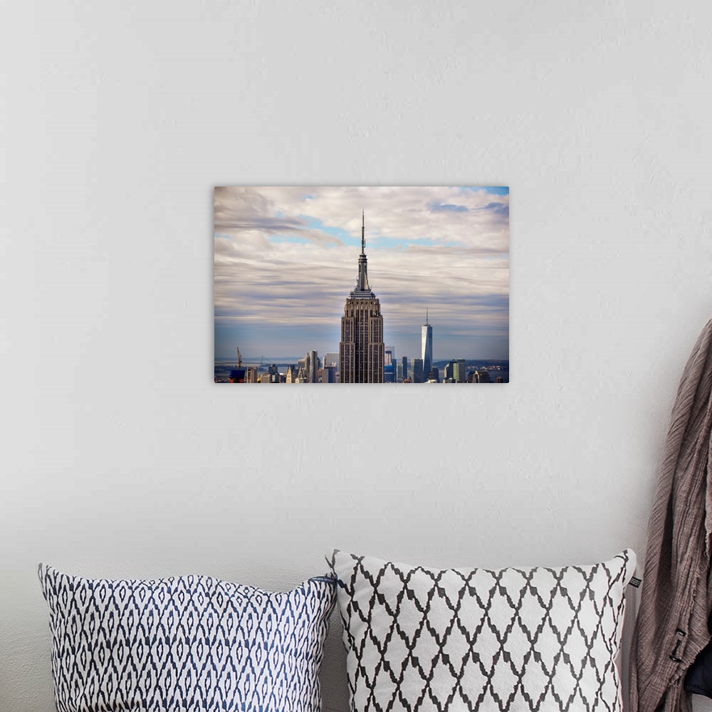 A bohemian room featuring Top view of the Empire State Building Broadcast Tower against dramatic clouds.