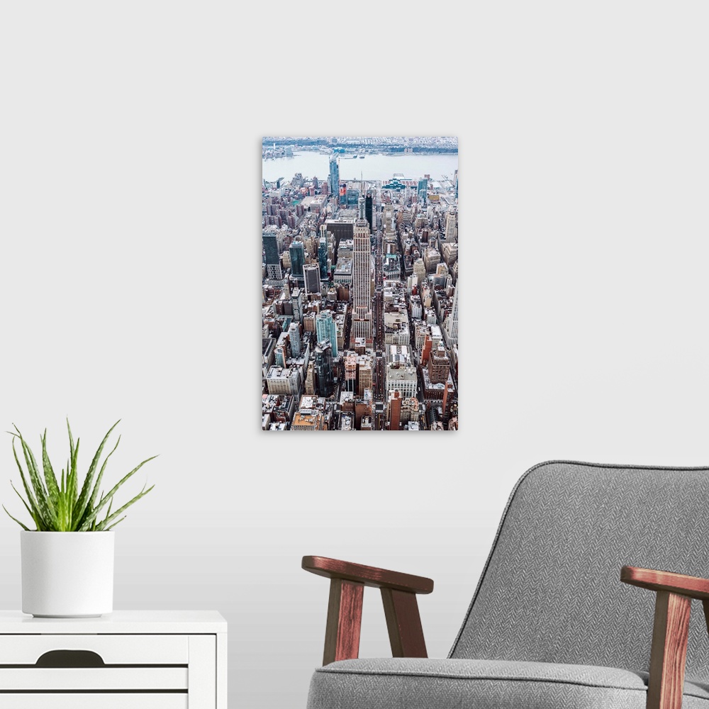 A modern room featuring Aerial view of the Empire State Building surrounded by skyscrapers in New York City.
