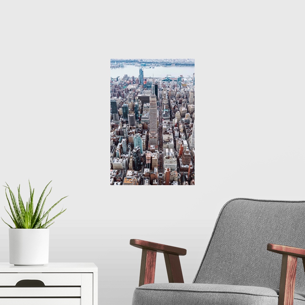 A modern room featuring Aerial view of the Empire State Building surrounded by skyscrapers in New York City.