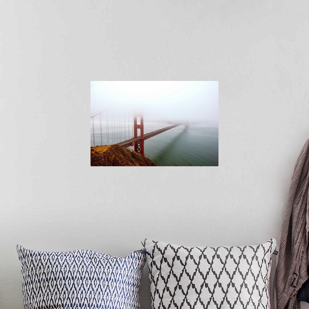 A bohemian room featuring Landscape photograph of fog taking over the Golden Gate Bridge.