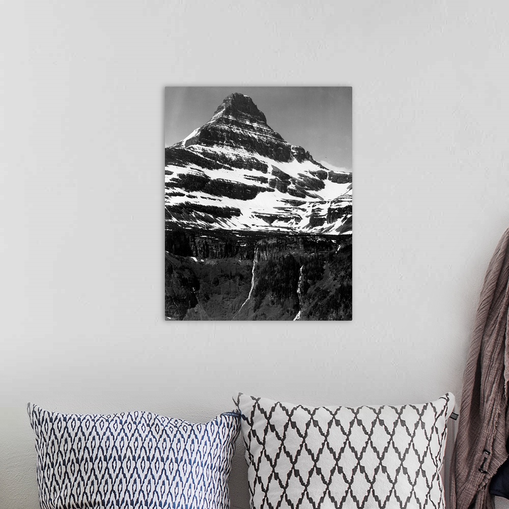 A bohemian room featuring In Glacier National Park, vertical, full view of snow covered mountain, including area below timb...