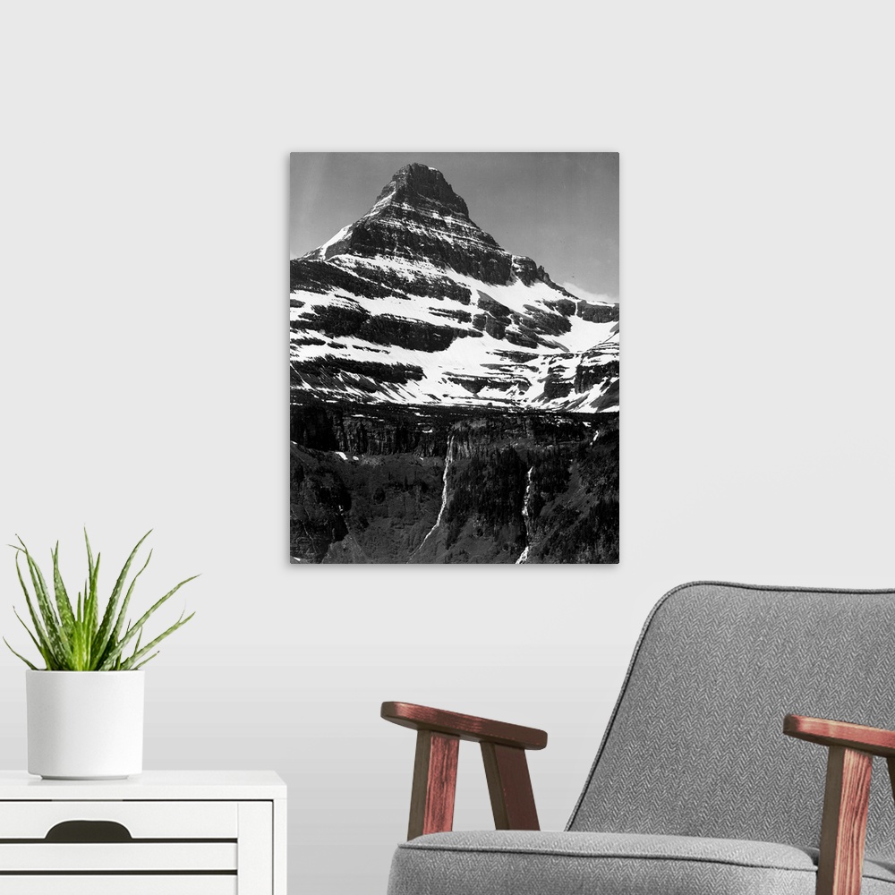 A modern room featuring In Glacier National Park, vertical, full view of snow covered mountain, including area below timb...