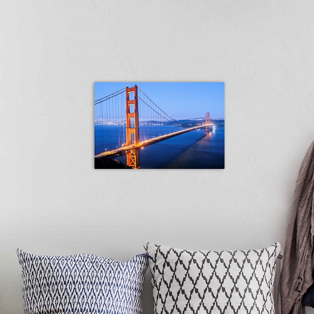 A bohemian room featuring Cool toned photograph of the Golden Gate Bridge lit up at twilight with the city lights in the ba...