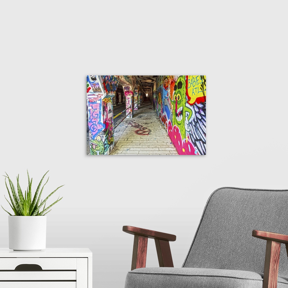 A modern room featuring Street art covers the walls, floors, and columns of the Krog Street Tunnel, connecting Inman Park...